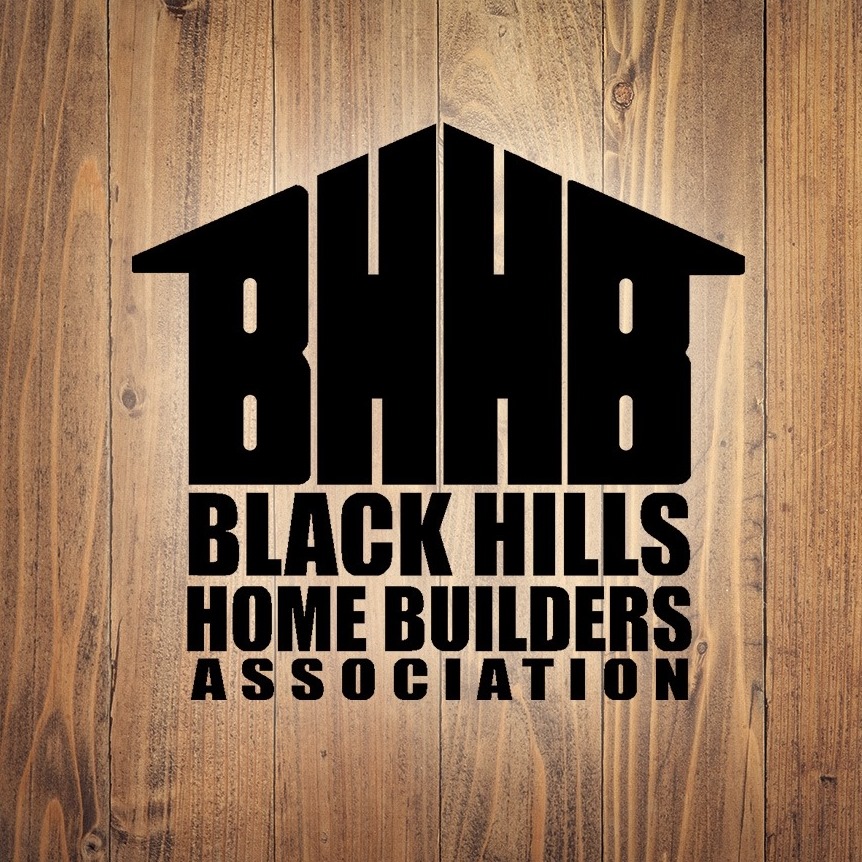 Black Hills Home Builders Association Logo with Black Lettering and White Outline on Wood background.