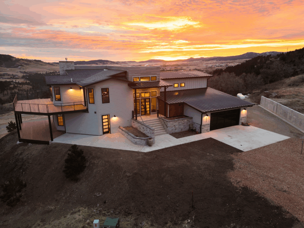 Modern custom home in Spearfish, SD, built by Legacy Custom Homes & Design with sunset views, and attached garage.