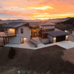Modern custom home in Spearfish, SD, built by Legacy Custom Homes & Design with sunset views, and attached garage.