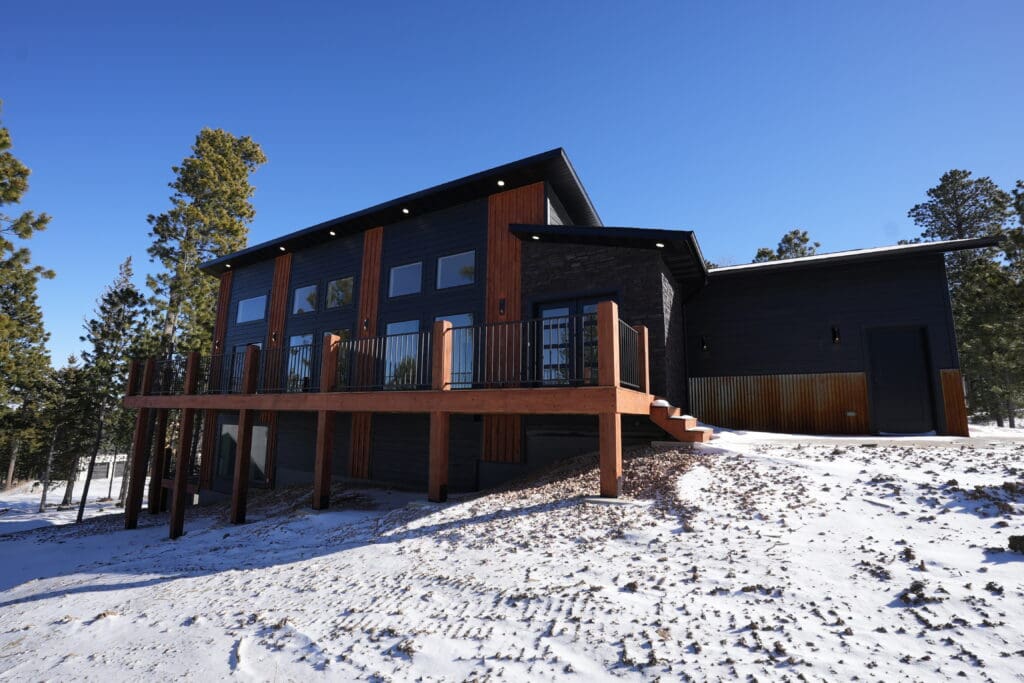 Modern mountain home at 11250 Overlook Pass in Lead, South Dakota, featuring elevated deck, contemporary design, and scenic Black Hills surroundings.