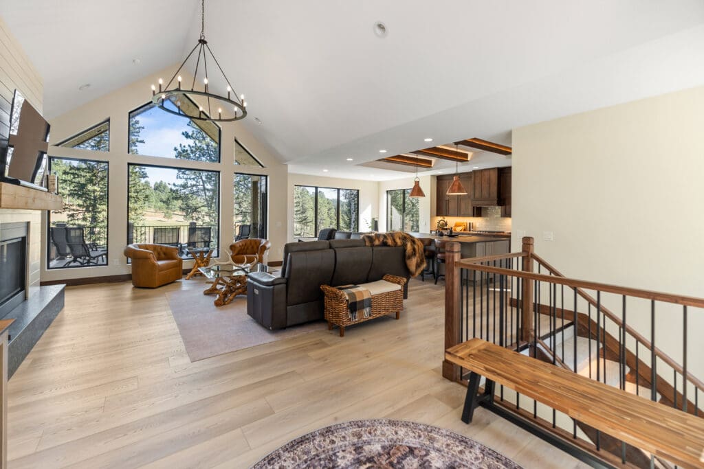 Open living room in a Three Peaks Ranch custom home built by Legacy Custom Homes & Design with large windows, vaulted ceilings, and mountain views.