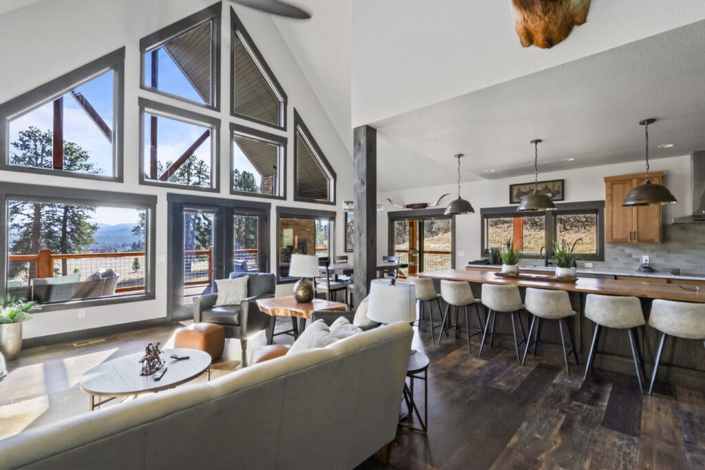 Luxury custom home interior built by Legacy Custom Homes & Design in Sturgis, SD, featuring an open-concept living area, floor-to-ceiling windows, custom kitchen, oversized island, and panoramic Black Hills views.